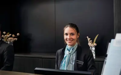 Lächelnde Hotelfachfrau mit Schal, bereit für ihre Weiterbildung.