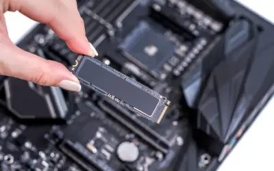 Eine Hand hält eine M.2 SSD, bereit für den Einbau in den entsprechenden ssd steckplatz mainboard.