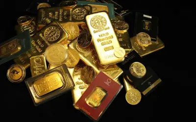 Złote sztabki i monety, w tym jedna o wadze 1 KILO. Widać różne gramatury i producentów, każdy z nich ma swoją wartość, a ile waży sztabka złota zależy od jej rozmiaru.