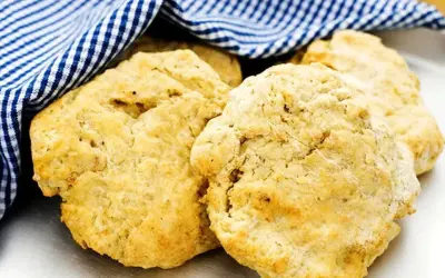 Nyttiga scones, gyllene och fluffiga, vilar under en blåvitrutig handduk. Perfekt för en hälsosam fika.