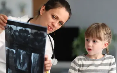 Lekarka, być może neuropsycholog, pokazuje dziecku wyniki rezonansu.