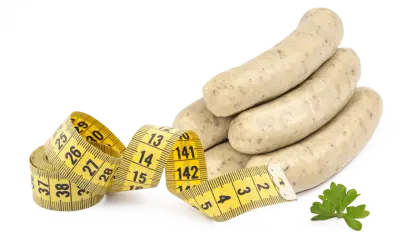 Bratwurst roh essen? Ein Maßband zeigt, dass man auf die Figur achten sollte. Ein Petersilienblatt liegt daneben.