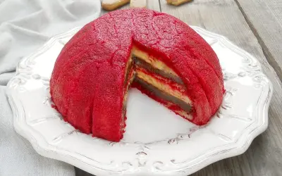 Zuppa inglese, un dessert a cupola con strati di crema e pan di Spagna, ricoperto da una glassa rossa vibrante.