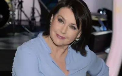 Elżbieta Jaworowicz, znana z programu "Na własne oczy", w błękitnej bluzce. Wiele osób zastanawia się, ile lat ma Elżbieta Jaworowicz.