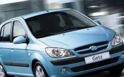 Błękitny Hyundai Getz w ruchu miejskim, z rozmytym tłem sugerującym prędkość.