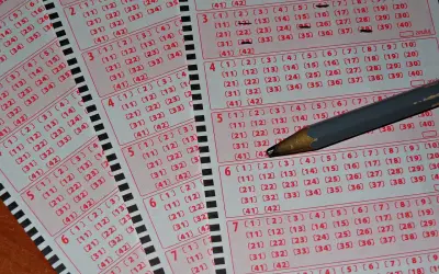 Kupony lotto z zaznaczonymi liczbami i ołówkiem. Zastanawiasz się, dlaczego niektórzy gracze zostawiają w kolekturach tylko niedrapane kody?
