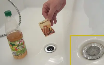 Hilfe bei verstopftem Waschbecken: Backpulver und Essig werden in den Abfluss gegeben, um die Verstopfung zu lösen.