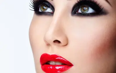 Occhi con smokey eyes e labbra sensuali con trucco con rossetto rosso brillante.