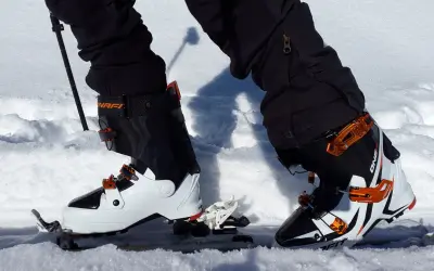 Skitury co to? Widok z perspektywy narciarza w butach i nartach skiturowych, gotowego do podboju ośnieżonych szlaków.