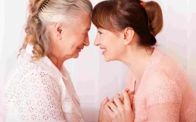 Un abbraccio tra madre e figlia, un momento di affetto che può aiutare a gestire i sintomas de alzheimer, con mani che si stringono.