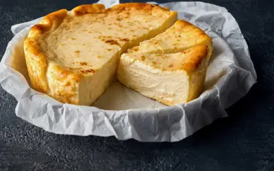 Un délicieux fiadone, recette corse, est servi sur du papier sulfurisé. Sa croûte dorée et sa texture crémeuse invitent à la dégustation.
