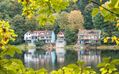 Malownicze domki nad jeziorem, idealne na jednodniowe wycieczki z Wrocławia. Jesienne liście dodają uroku.