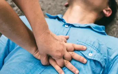 Dłonie wykonują uciski klatki piersiowej, ratując życie. To RKO.