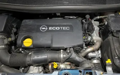 Silnik Ecotec w Opel Meriva 1.7 CDTI. Widoczny czarny plastikowy dekiel z logo Opla i napisem Ecotec, żółty korek oleju, przewody i elementy układu dolotowego.