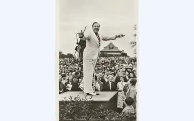 Sven Lilja leder allsången på Skansen. En glad publik lyssnar.