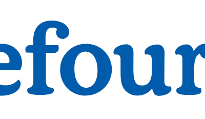 Logo Carrefour z niebieskim napisem i charakterystycznym symbolem strzałki w kolorach czerwonym i niebieskim.