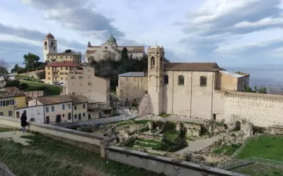 Panoramica del capoluogo Marche con antiche rovine, chiese e il mare all'orizzonte.