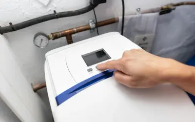 Main d'une personne appuyant sur le bouton "SET" d'un adoucisseur d'eau. Le manomètre indique la pression. Le 16 c'est quoi ?