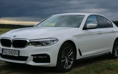 Białe BMW 530 na tle burzowego nieba. Elegancka limuzyna z polskimi tablicami rejestracyjnymi SC 0420U.