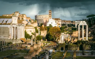 Ruiny Forum Romanum, serce starożytnego Rzymu, pod burzowym niebem. W oddali Koloseum.