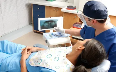 Dentysta omawia z pacjentką zdjęcie RTG, szukając rozwiązań co zamiast leczenia kanałowego.