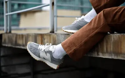 Szare New Balance na nogach w brązowych sztruksach. Zastanawiasz się, czy new balance można prać w pralce? Te wyglądają na czyste!