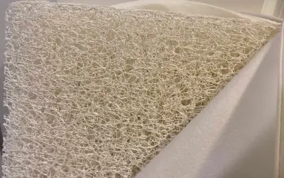 Close-up of a white, airy, woven material, revealing what the Newton mattress is made of: a breathable, open-cell core.