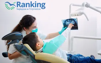 Dentystka w masce pokazuje dziecku zdjęcie rentgenowskie zębów.