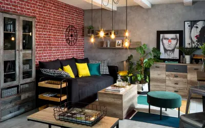 Męski pokój inspiracje: loftowy salon z ceglaną ścianą, czarną kanapą, drewnianymi meblami i industrialnymi lampami.
