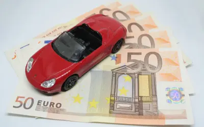 Czerwony samochodzik na banknotach 50 euro. Koszt zakupu auta i podatek PCC-3.