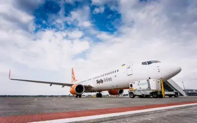 Samolot SkyUp Airlines gotowy do startu. W tle błękitne niebo z chmurami.