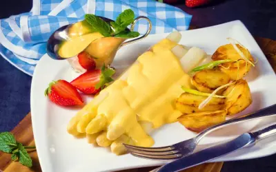 Vit sparris med krämig hollandaisesås, rostade potatisar och jordgubbar. Ett perfekt hollandaisesås recept för en lyxig måltid.