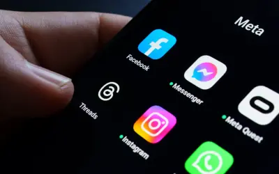 Palec dotyka ekranu telefonu z ikonami aplikacji Meta: Facebook, Messenger, Instagram, Threads. Awaria Facebooka sprawia, że użytkownicy szukają alternatyw.