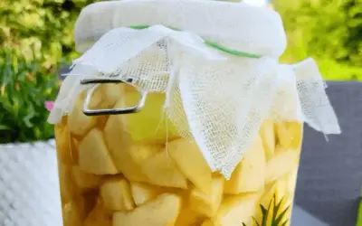 Domowy ocet jabłkowy jak pić? W słoiku jabłka w zalewie, gotowe do fermentacji.