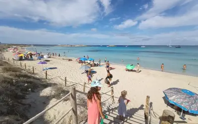 Giornata di sole a Formentera con bambini, tra sabbia bianca, mare cristallino e tante famiglie che si godono la vacanza.