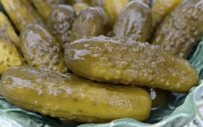 Kosz pełen soczystych, zielonych ogórków kiszonych, które wyglądają na puste w środku, gotowe do chrupania.