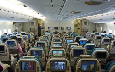 Blick in die Kabine eines A380. Viele Sitze mit Bildschirmen, die zeigen, wie viele Passagiere in den A380 passen.