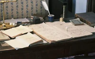 Bureau ancien avec des documents manuscrits, une plume d'oie et un encrier. Peut-être les préparatifs d'un généafrance mariage.