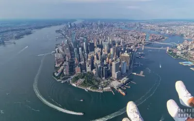 Widok z lotu ptaka na Manhattan, pełen drapaczy chmur, rzekę i mosty. Widać, w jakim stanie jest Nowy Jork – tętniący życiem, dynamiczny.