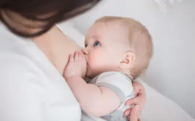 Niemowlę z niebieskimi oczami karmione piersią. Czas trwania nawalu laktacyjnego jest indywidualny.