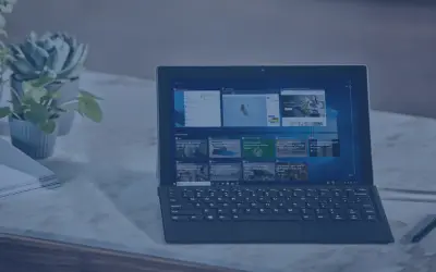 Nowoczesny laptop z klawiaturą i ekranem dotykowym, obok rośliny i stosu papierów. Idealny do pracy, gdy środek trwały od jakiej kwoty jest potrzebny.