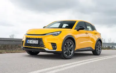 Żółty, kompaktowy SUV, który może być najmniejszym Lexusem, stoi na drodze.