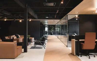 Un espace de travail innovant avec des canapés en cuir, des chaises modernes et des bureaux vitrés.