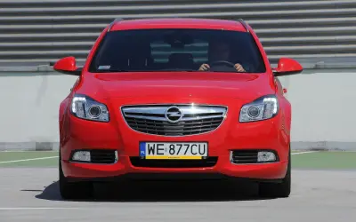 Czerwony Opel Insignia z tablicą WE 877CU. Poznaj jego imponujące opel insignia wymiary i styl.