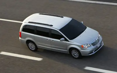 Srebrny Lancia Voyager jedzie po autostradzie.