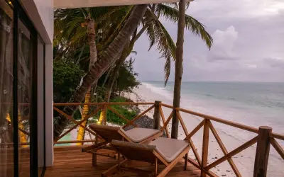 Relaks na tarasie z widokiem na plażę i ocean. Dwa leżaki czekają na gości, którzy chcą poczuć klimat pili pili zanzibar.