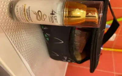 Krem pod oczy 4 Lift Skin ujędrnia i wygładza skórę. Złota pompka i czarna kosmetyczka z kocimi uszami.