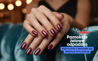 Dłonie z bordowymi paznokciami żelowymi. Dowiedz się, dlaczego żel odchodzi od wolnego brzegu i jak temu zapobiec.