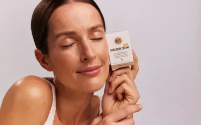 Frau mit geschlossenen Augen hält eine Tagescreme mit Hyaluronsäure. Welches Hyaluron ist das beste? Diese Creme verspricht intensive Pflege.