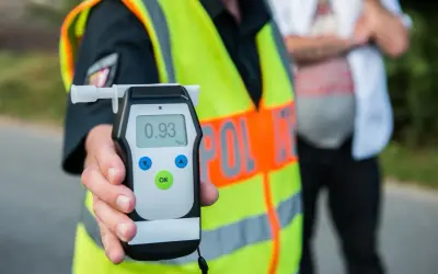 Policjant pokazuje alkomat z wynikiem 0.93 promila. To wynik, który jasno pokazuje, ile można mieć promili, by nie przekroczyć dopuszczalnej normy.